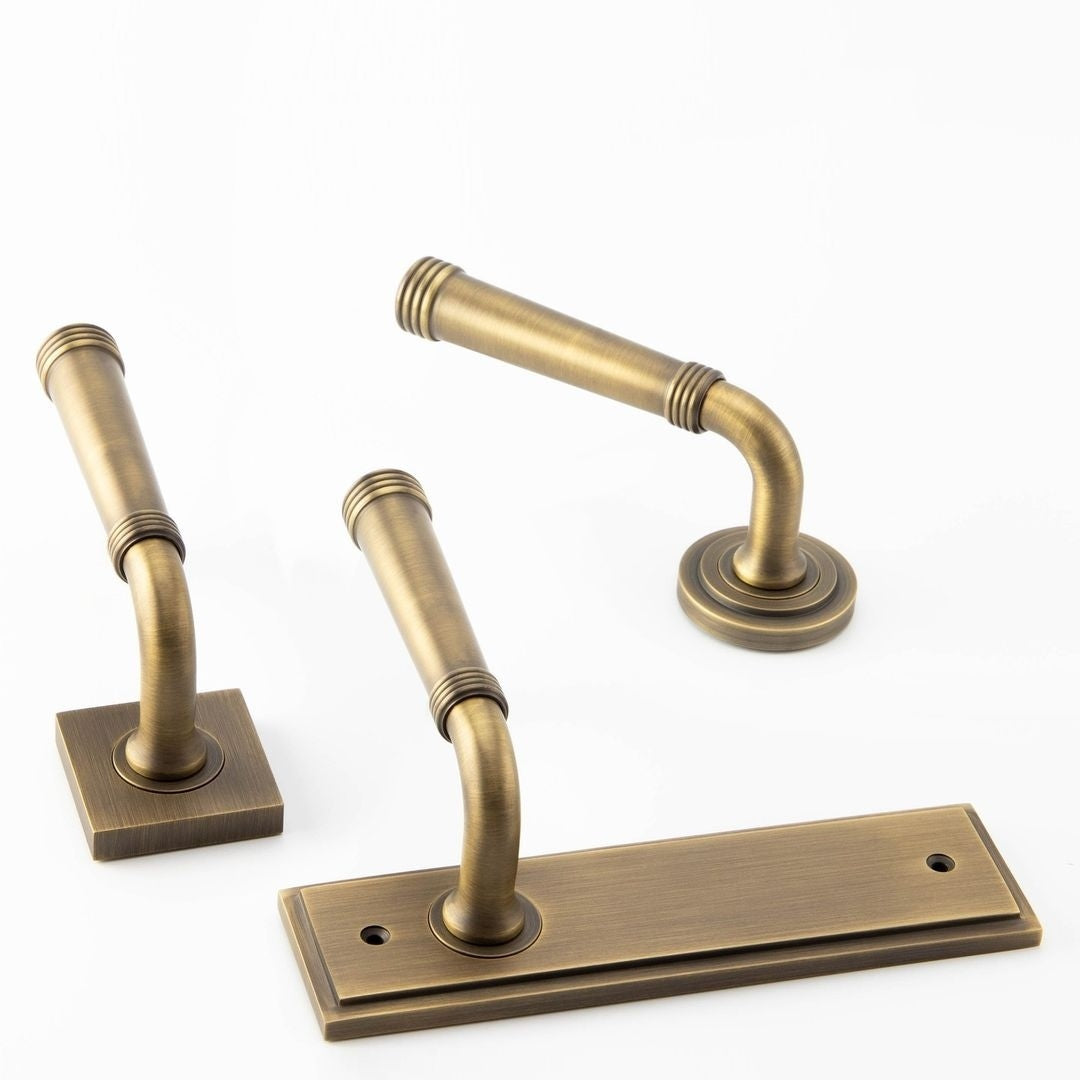 Image showing a range of door handles on roses and backplates from the Burlington collection by Frelan Hardware in Antique Brass.  Available to order from Trade Door handles