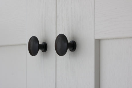 Image showing a pair of cabinet knobs in smooth black from Stonebridge.  Available to order from Trade Door Handles