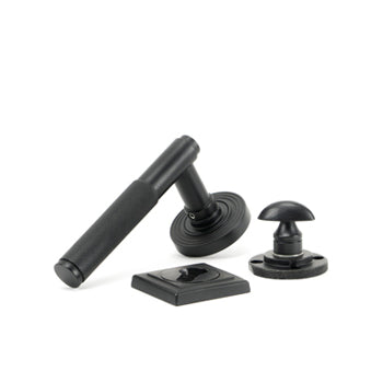 Image showing a door handle, escutcheon and bathroom turn in Matt Black by From The Anvil.  Available to order from Trade Door Handles in Kendal