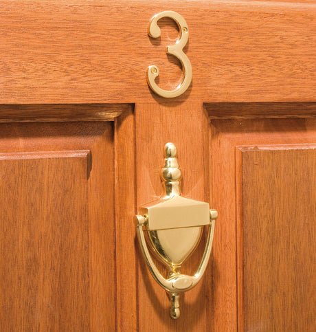 Image showing a door knocker and the number three on a door in polished brass made by Carlisle Brass available to order from Trade Door Handles