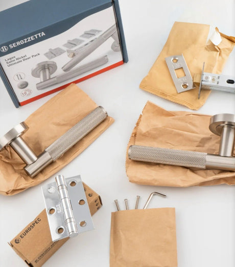 This is an image of a Carlisle Brass door handle pack showing the handles, hinges and latch