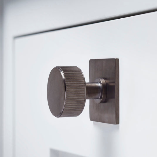 This image is a cabinet knob on a back plate by Alexander and Wilks in Dark Bronze.  Available to order from Trade Door Handles in Kendal