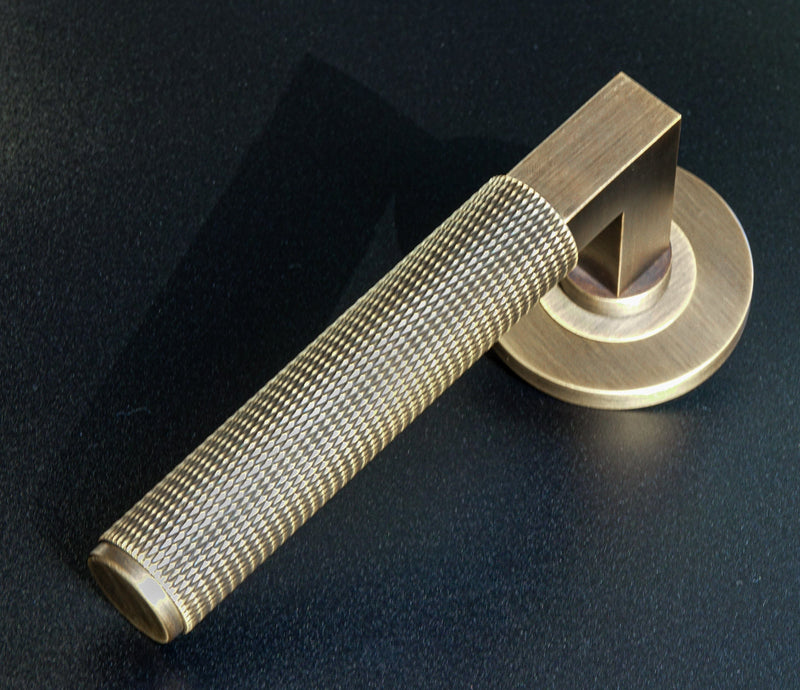 This is an image of Antique Brass Door Handle on Round Rose by Alexander and Wilks