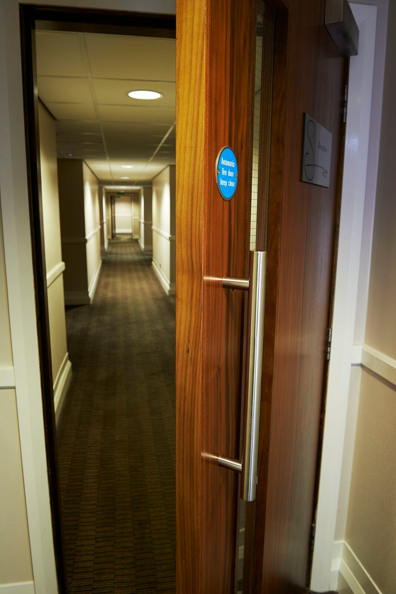 Carlisle Brass Stainless Steel Pull Handle on a hotel door PAT1300