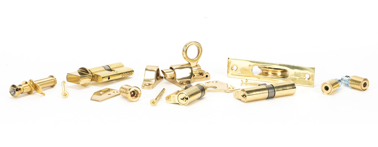 Image showing a range of From The Anvil Ironmongery and Hardware in Lacquered Brass.  Available to order from Trade Door Handles in Kendal