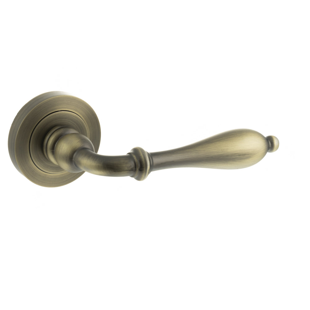 Quality image of Old English Wrexham Lever Door Handle on Round Rose - Matt Antique Brass | Sku. oe142mab | available from Trade Door Handles.