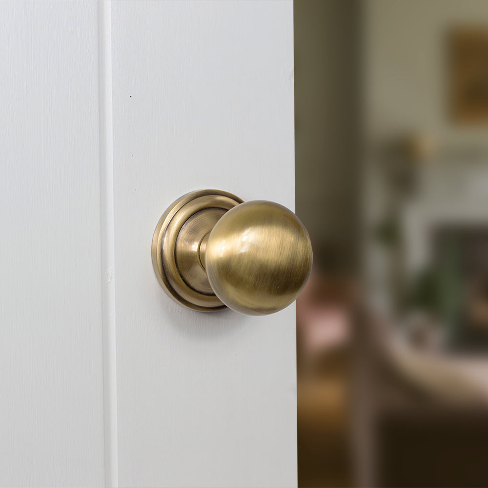 Quality image of Old English Harrogate Solid Brass Mushroom Mortice Knob on Concealed Fix Rose - Antique Brass | Sku. oe58mmkab | available from Trade Door Handles.