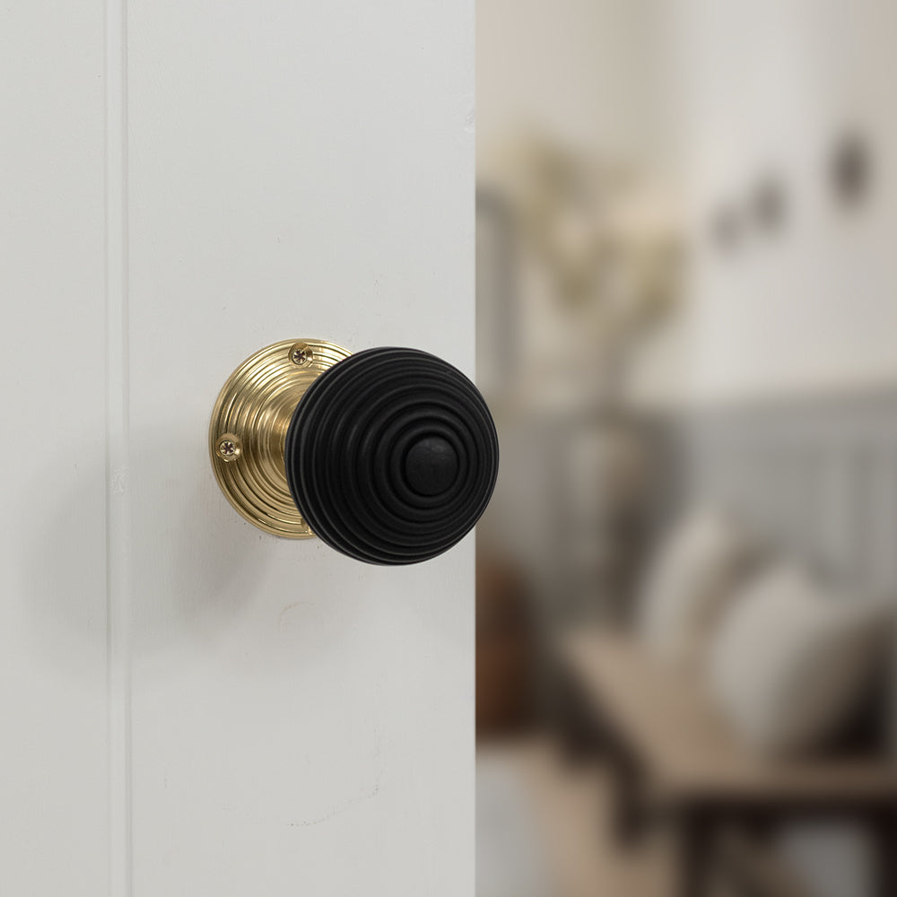 Quality image of Old English Whitby Ebony Wood Reeded Beehive Mortice Knob on Face Fix Rose - Polished Brass | Sku. oe60rremkpb | available from Trade Door Handles.