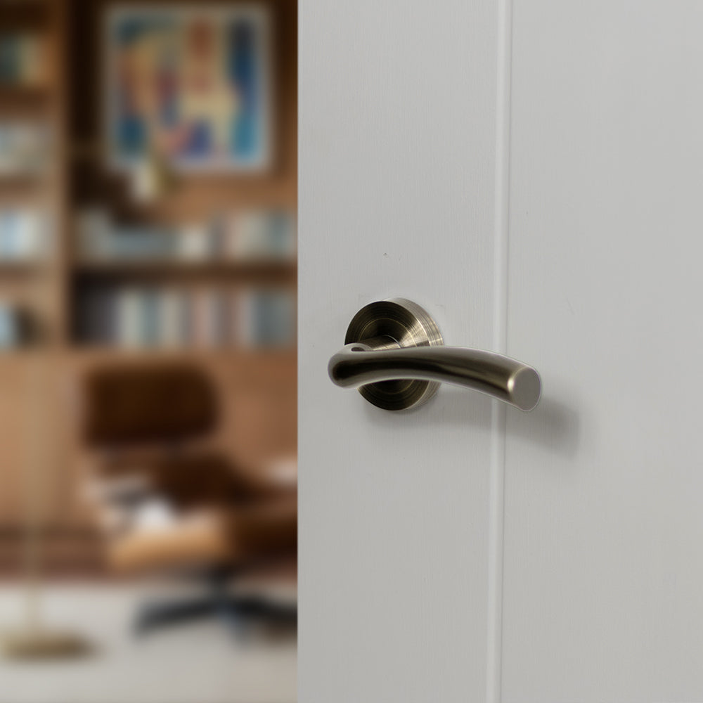 Quality image of STATUS Texas Lever Door Handle on Round Rose - Antique Brass | Sku. s35rab | available from Trade Door Handles.