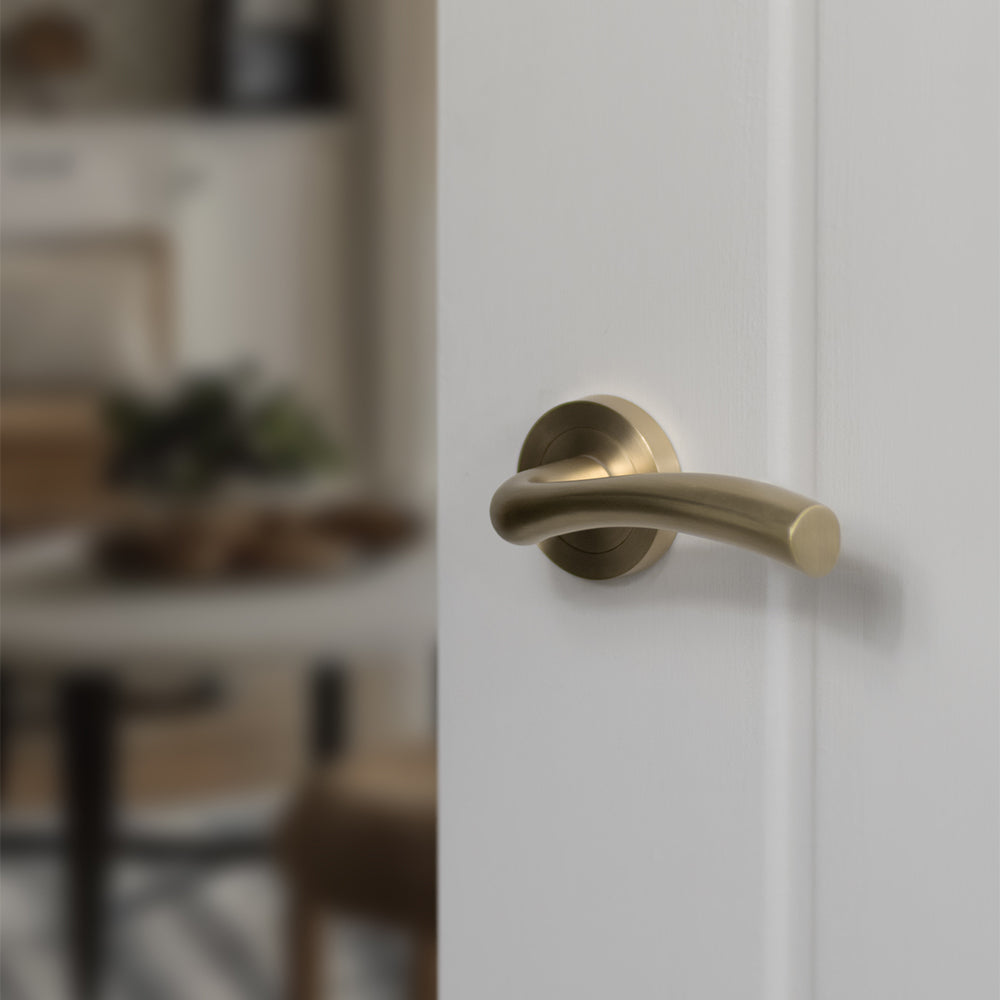 Quality image of STATUS Texas Lever Door Handle on Round Rose - Satin Brass | Sku. s35rsb | available from Trade Door Handles.