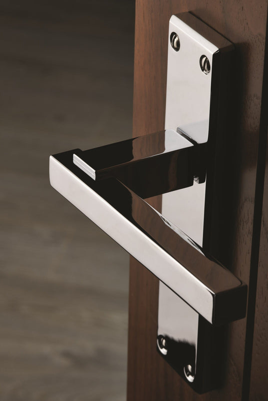 This is a door handle from Carlisle Brass showing a polished chrome door handles on a walnut door.