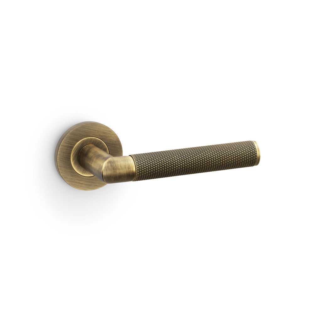 High quality image of Alexander & Wilks - Harrier Knurled Lever on Round Rose - Antique Brass | Sku. aw210ab | Trade Door Handles.