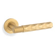 This is an image showing Alexander & Wilks Spitfire Diamond Cut Lever on Round Rose - Satin Brass PVD - aw226-SBPVD available to order from Trade Door Handles in Kendal, quick delivery and discounted prices.