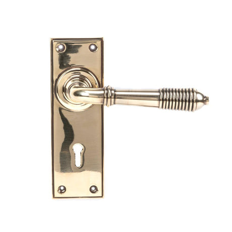 This is an image showing From The Anvil - Aged Brass Reeded Lever Lock Set available from trade door handles, quick delivery and discounted prices