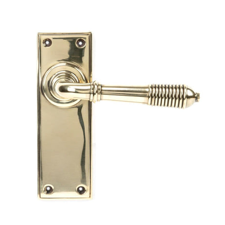 This is an image showing From The Anvil - Aged Brass Reeded Lever Latch Set available from trade door handles, quick delivery and discounted prices
