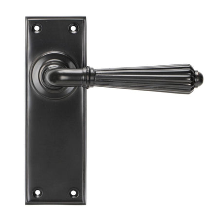 This is an image showing From The Anvil - Aged Bronze Hinton Lever Latch Set available from trade door handles, quick delivery and discounted prices