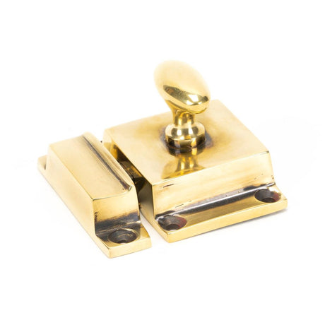 This is an image showing From The Anvil - Aged Brass Cabinet Latch available from trade door handles, quick delivery and discounted prices