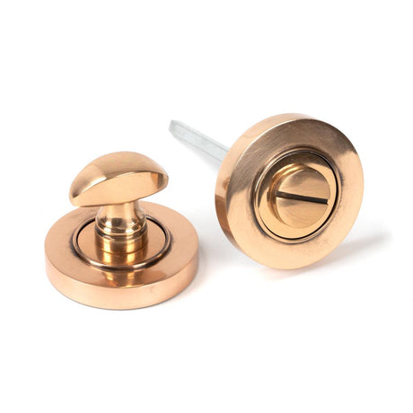This is an image showing From The Anvil - Polished Bronze Round Thumbturn Set (Plain) available from trade door handles, quick delivery and discounted prices