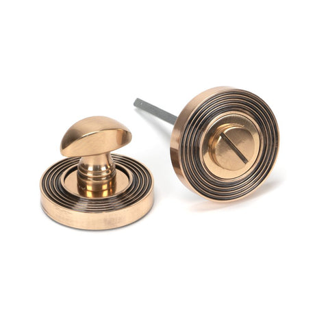 This is an image showing From The Anvil - Polished Bronze Round Thumbturn Set (Beehive) available from trade door handles, quick delivery and discounted prices