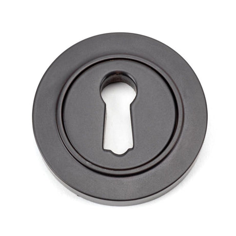 This is an image showing From The Anvil - Aged Bronze Round Escutcheon (Plain) available from trade door handles, quick delivery and discounted prices