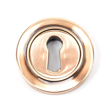This is an image showing From The Anvil - Polished Bronze Round Escutcheon (Plain) available from trade door handles, quick delivery and discounted prices