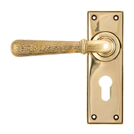 This is an image showing From The Anvil - Aged Brass Hammered Newbury Lever Euro Lock Set available from trade door handles, quick delivery and discounted prices
