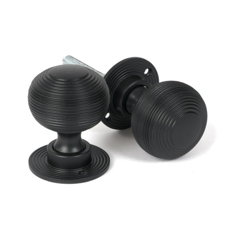 This is an image showing From The Anvil - Matt Black Heavy Beehive Mortice/Rim Knob Set available from trade door handles, quick delivery and discounted prices