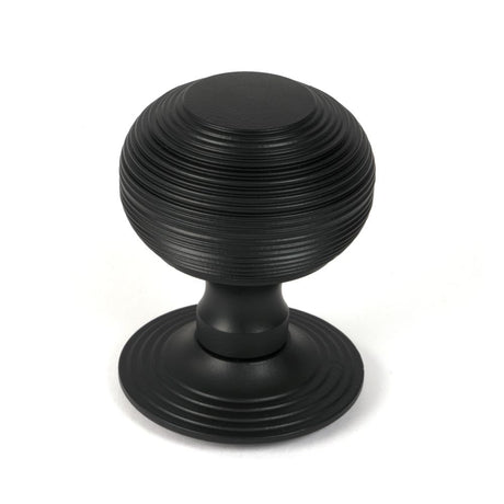 This is an image showing From The Anvil - Matt Black Beehive Centre Door Knob available from trade door handles, quick delivery and discounted prices