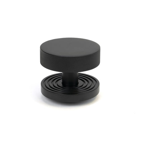 This is an image showing From The Anvil - Matt Black Brompton Centre Door Knob (Beehive) available from trade door handles, quick delivery and discounted prices