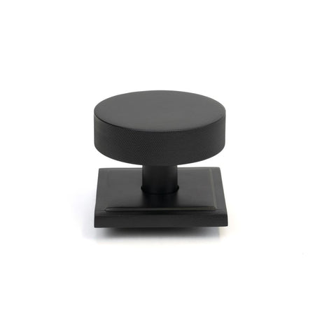 This is an image showing From The Anvil - Matt Black Brompton Centre Door Knob (Square) available from trade door handles, quick delivery and discounted prices