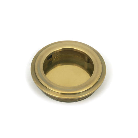 This is an image showing From The Anvil - Aged Brass 60mm Art Deco Round Pull available from trade door handles, quick delivery and discounted prices