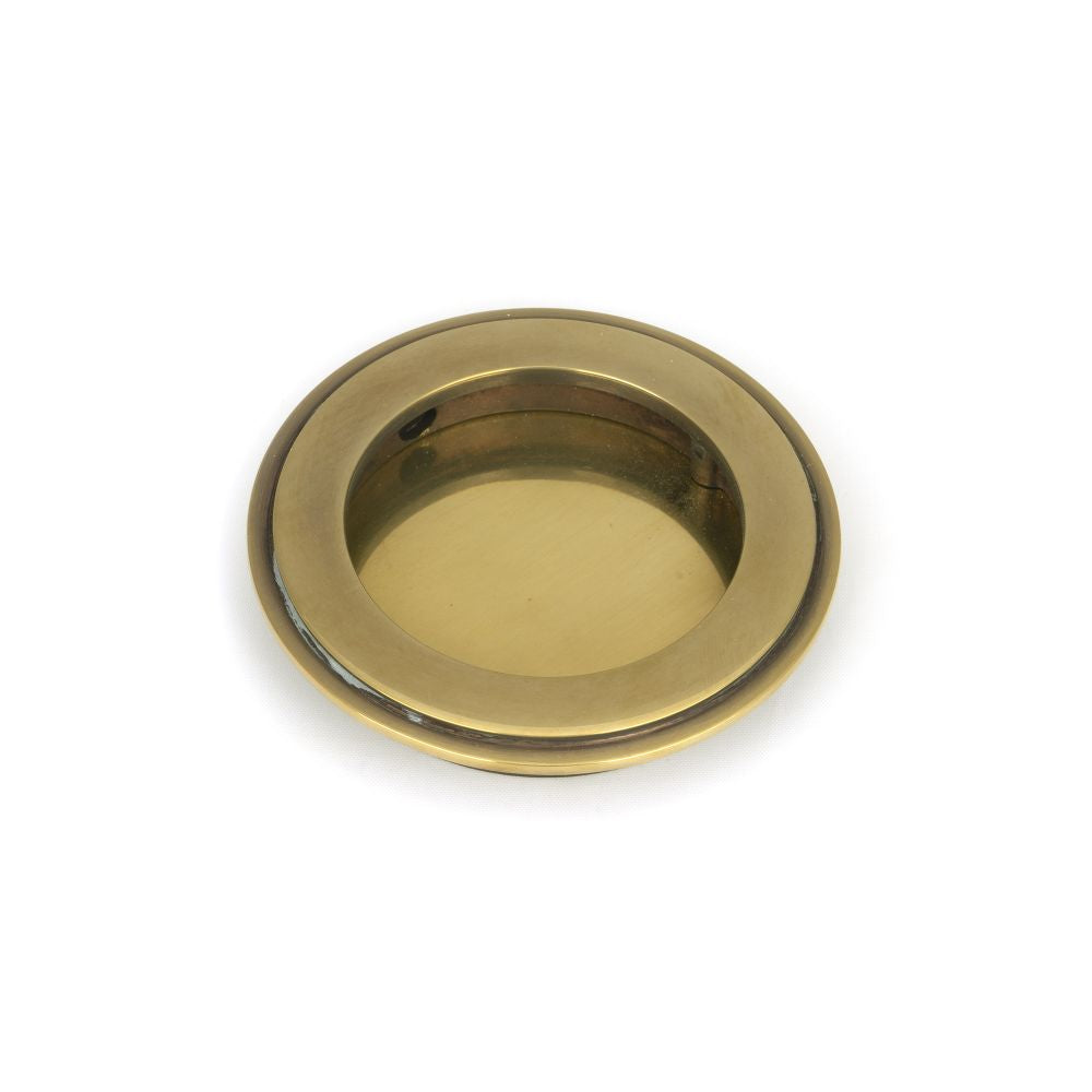 This is an image showing From The Anvil - Aged Brass 75mm Art Deco Round Pull available from trade door handles, quick delivery and discounted prices