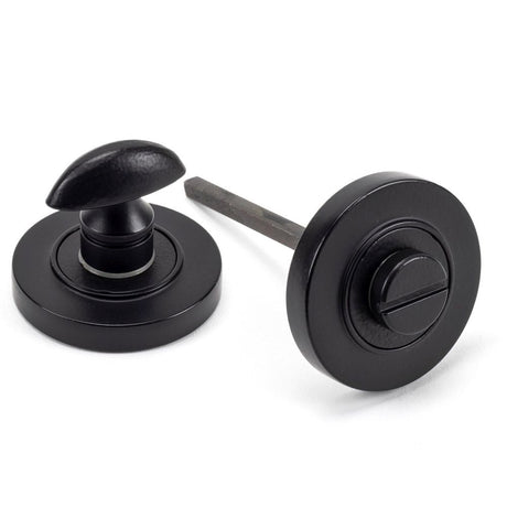 This is an image showing From The Anvil - Matt Black Round Thumbturn Set (Plain) available from trade door handles, quick delivery and discounted prices