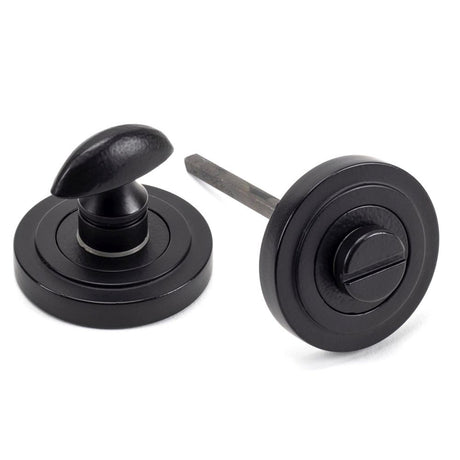 This is an image showing From The Anvil - Matt Black Round Thumbturn Set (Art Deco) available from trade door handles, quick delivery and discounted prices
