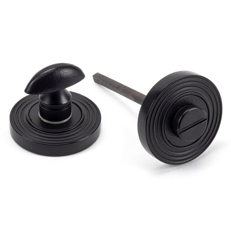 This is an image showing From The Anvil - Matt Black Round Thumbturn Set (Beehive) available from trade door handles, quick delivery and discounted prices