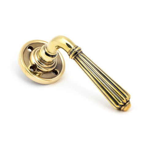 This is an image showing From The Anvil - Aged Brass Hinton Lever on Rose Set - Unsprung available from trade door handles, quick delivery and discounted prices
