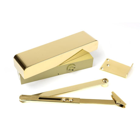 This is an image showing From The Anvil - Polished Brass Size 2-5 Door Closer & Cover available from trade door handles, quick delivery and discounted prices