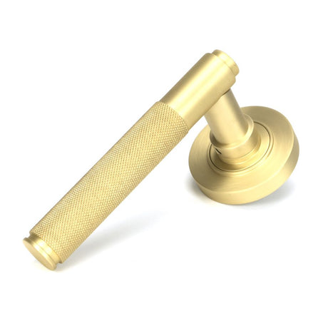 This is an image showing From The Anvil - Satin Brass Brompton Lever on Rose Set (Plain) - Unsprung available from trade door handles, quick delivery and discounted prices
