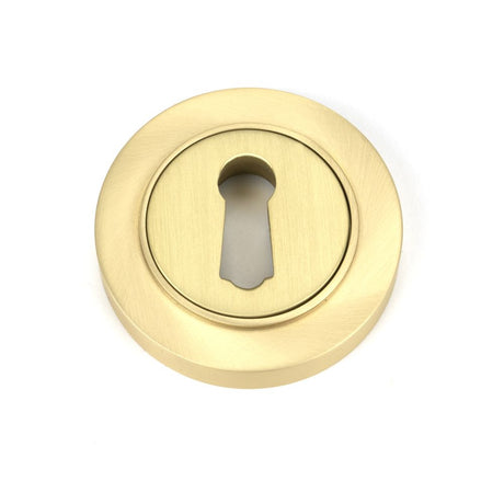 This is an image showing From The Anvil - Satin Brass Round Escutcheon (Plain) available from trade door handles, quick delivery and discounted prices