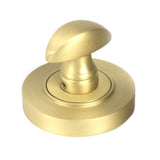 This is an image showing From The Anvil - Satin Brass Round Thumbturn Set (Plain) available from trade door handles, quick delivery and discounted prices