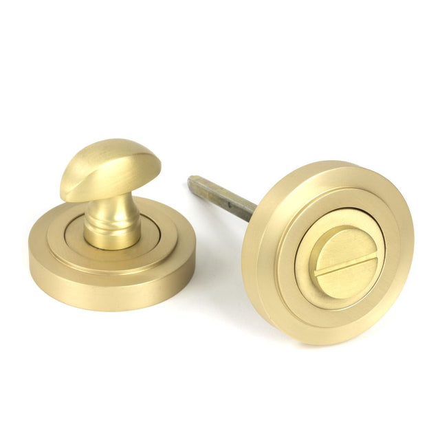 This is an image showing From The Anvil - Satin Brass Round Thumbturn Set (Art Deco) available from trade door handles, quick delivery and discounted prices