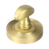 This is an image showing From The Anvil - Satin Brass Round Thumbturn Set (Beehive) available from trade door handles, quick delivery and discounted prices