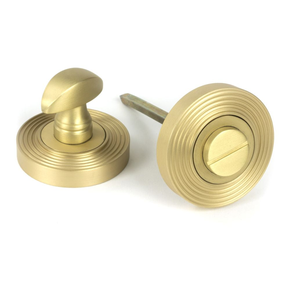 This is an image showing From The Anvil - Satin Brass Round Thumbturn Set (Beehive) available from trade door handles, quick delivery and discounted prices