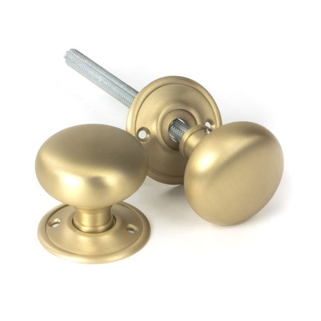 This is an image showing From The Anvil - Satin Brass Mushroom Mortice/Rim Knob Set available from trade door handles, quick delivery and discounted prices