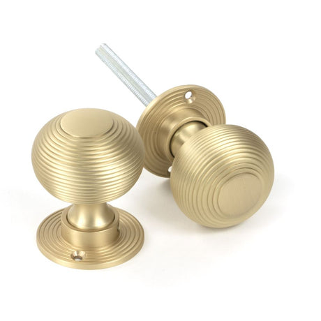 This is an image showing From The Anvil - Satin Brass Heavy Beehive Mortice/Rim Knob Set available from trade door handles, quick delivery and discounted prices