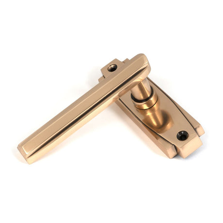 This is an image showing From The Anvil - Polished Bronze Art Deco Lever on Rose Set available from trade door handles, quick delivery and discounted prices