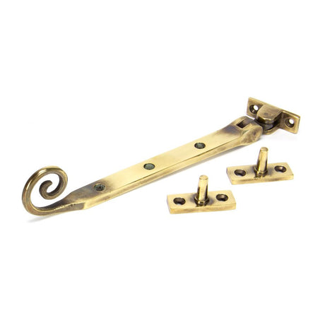 This is an image showing From The Anvil - Aged Brass 8" Monkeytail Stay available from trade door handles, quick delivery and discounted prices