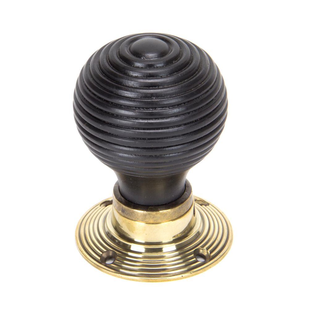 This is an image showing From The Anvil - Ebony & Aged Brass Beehive Mortice/Rim Knob Set available from trade door handles, quick delivery and discounted prices