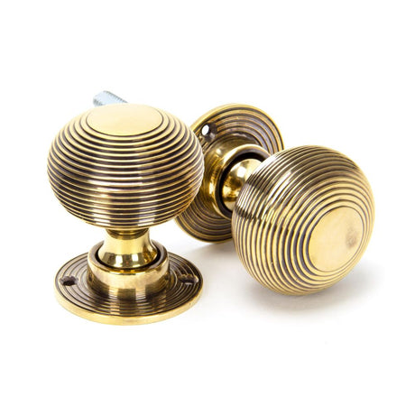 This is an image showing From The Anvil - Aged Brass Heavy Beehive Mortice/Rim Knob Set available from trade door handles, quick delivery and discounted prices