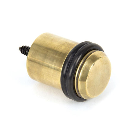 This is an image showing From The Anvil - Aged Brass Floor Mounted Door Stop available from trade door handles, quick delivery and discounted prices